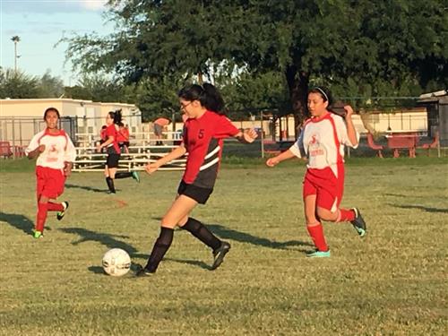 the girls soccer team plays outside
